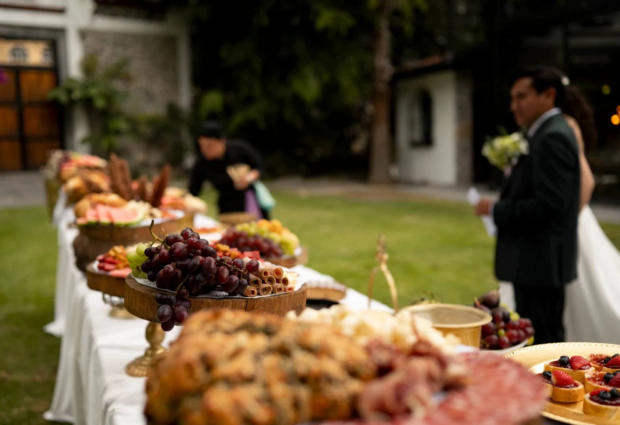 Mesa de bocadillos, fruta y detalles de una celebración al aire libre