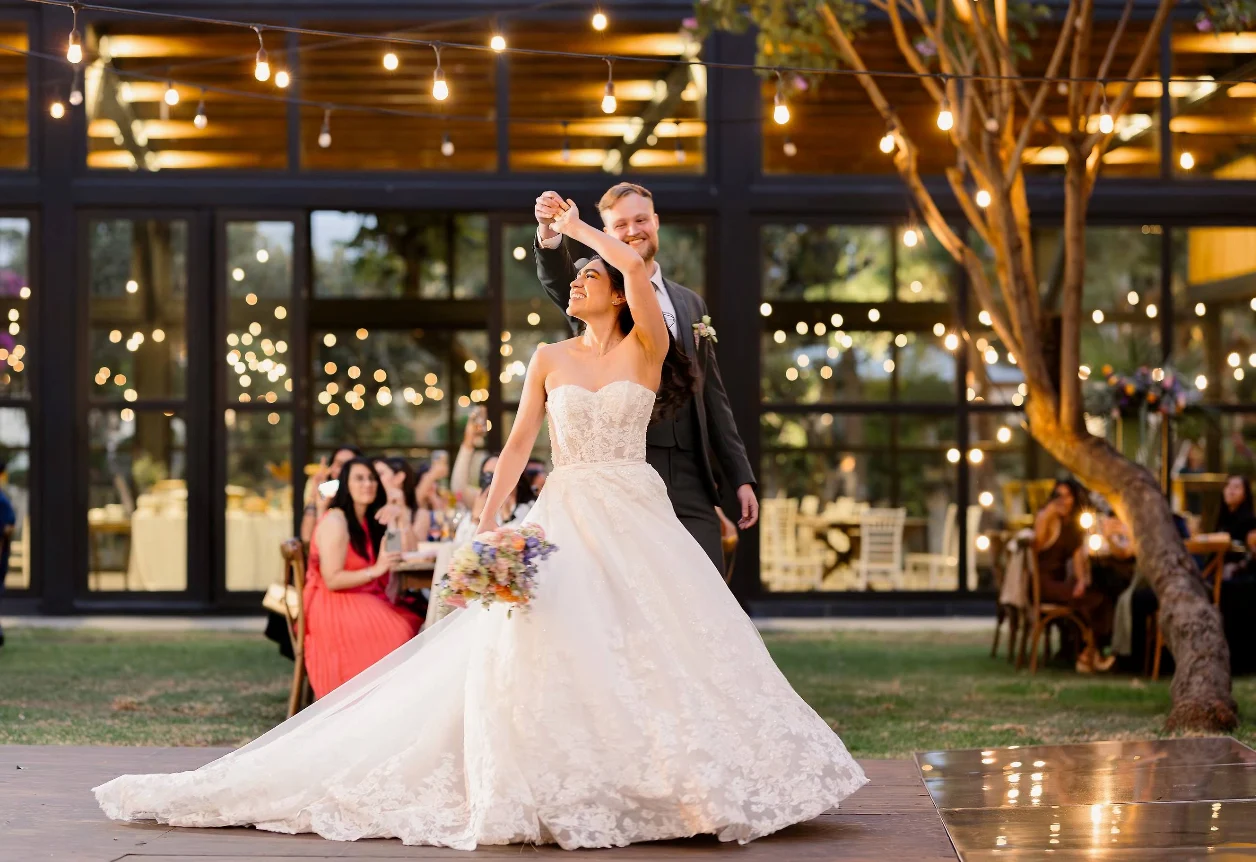 Una pareja celebra su boda bajo las luces del jardín